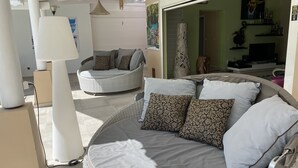 A sunlit room with a large, curved sofa and a smaller round seating area, both furnished with patterned cushions. - New! Villa Uhaïna, Zen and atypical (SAINT-FRANÇOIS)