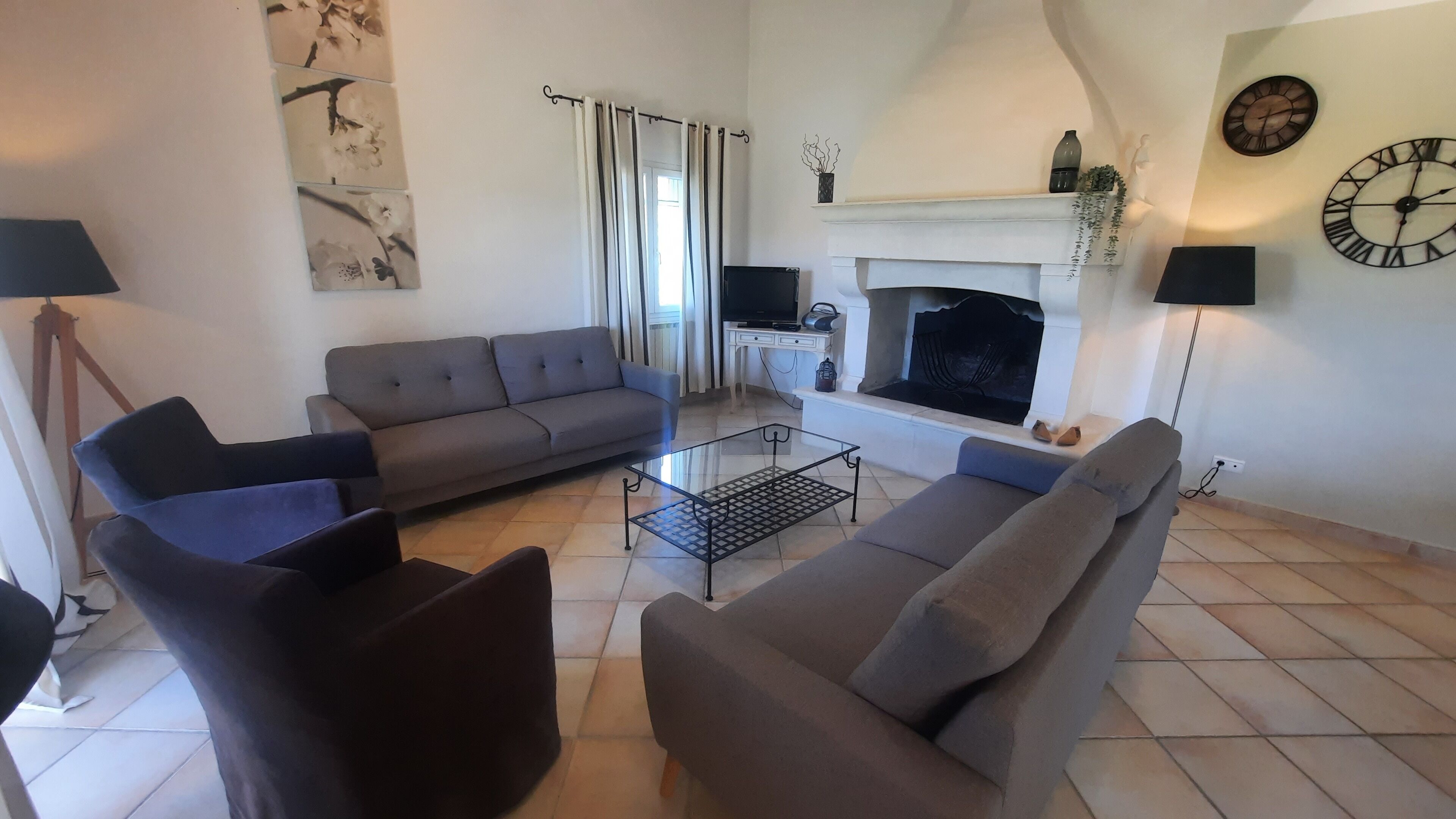 Una sala de estar con un sofá gris, una mesa de centro y una chimenea.