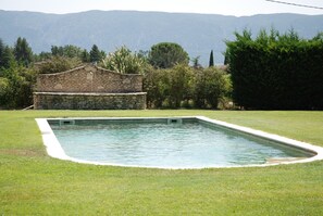 A rectangular swimming pool with a stone wall and a grassy lawn. - In PROVENCE, Face IN LUBERON, A LITTLE PIECE OF PARADISE, PRIVATE VILLA FOR 6 Pers (Cabrières-D'avignon)