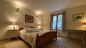 A bedroom with a wooden bed, two bedside tables with lamps, a window with curtains, and a framed picture on the wall. - Charming apartment in Provencal farmhouse in Saint-Rémy-de-Provence (Saint-Rémy-De-Provence)