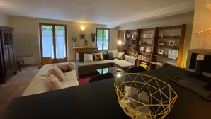 A living room with a sofa, a coffee table, and a bookshelf. - Charming apartment in Provencal farmhouse in Saint-Rémy-de-Provence (Saint-Rémy-De-Provence)