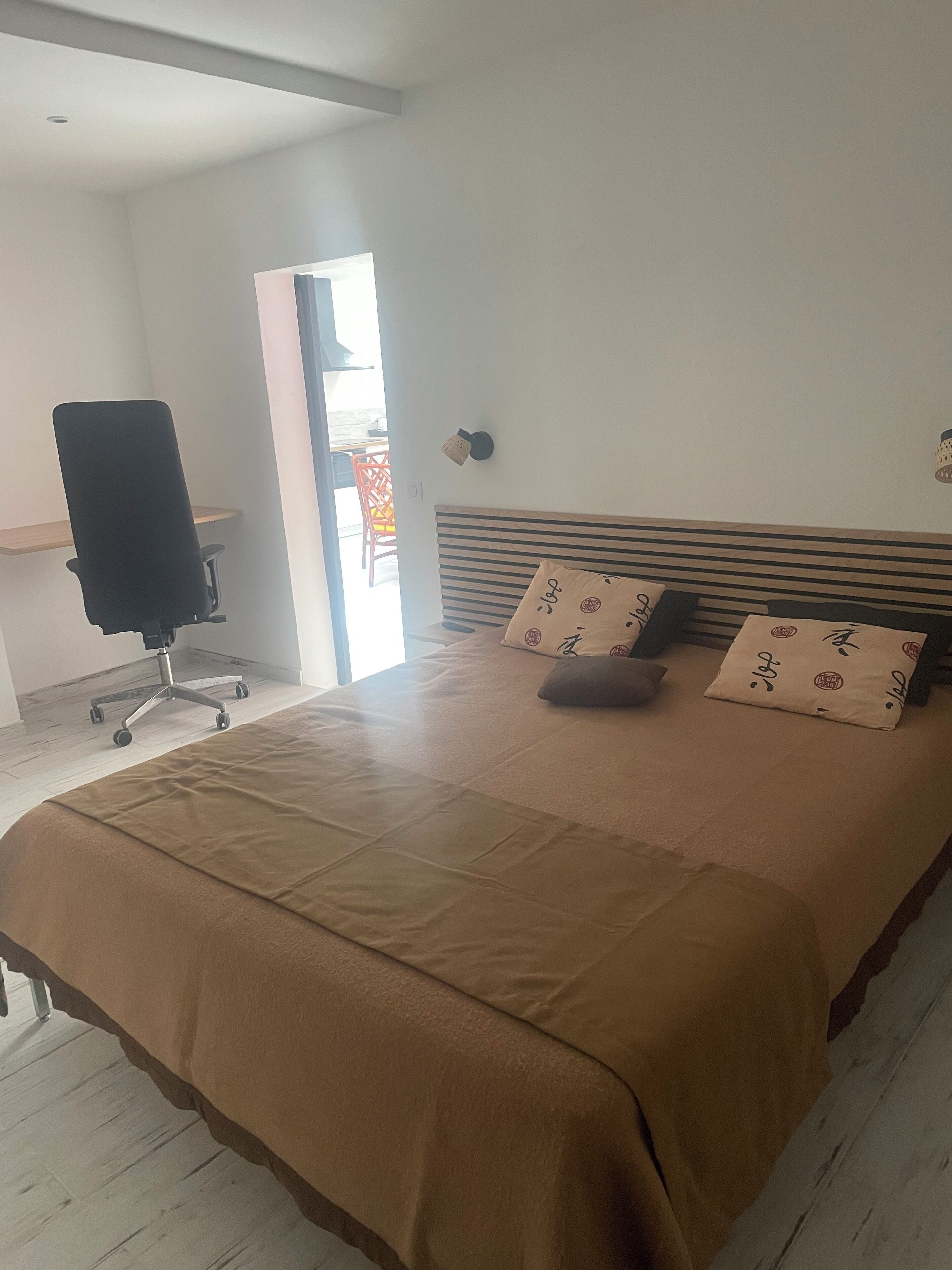 Ein Schlafzimmer mit einem großen Bett, einem Schreibtisch und einem Stuhl.