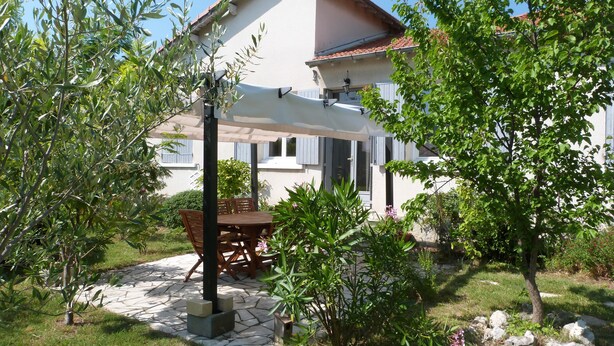 A house with a patio, a table, and chairs. - House 10 mn walk from the city center with shaded garden, olive trees.  (Uzès)