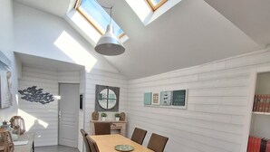 Un interior moderno con comedor, una estantería y un tragaluz.