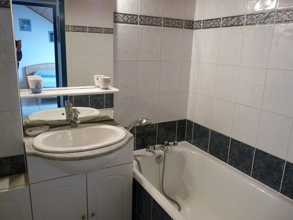 A bathroom with a sink, mirror, and bathtub. - COMFORTABLE APPT 2 PIECES - ARZON- 100m from the beach (Arzon)