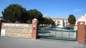 A gated entrance with a stone wall and a sign reading "LES QUAIS DE L'AMIRAUTE". - 54m² apartment rental with view of boats, shaded and sunny St Cyprien (Pyrénées-Orientales)
