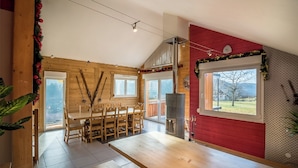 Una cocina amplia con armarios de madera, un comedor con mesa y sillas, y un gran ventanal que ofrece vistas al exterior.