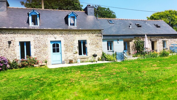 A stone house with a blue door and windows, a garden with flowers, and a clear sky. - A country cottage "Ti Gwen" (Plonévez-Du-Faou)
