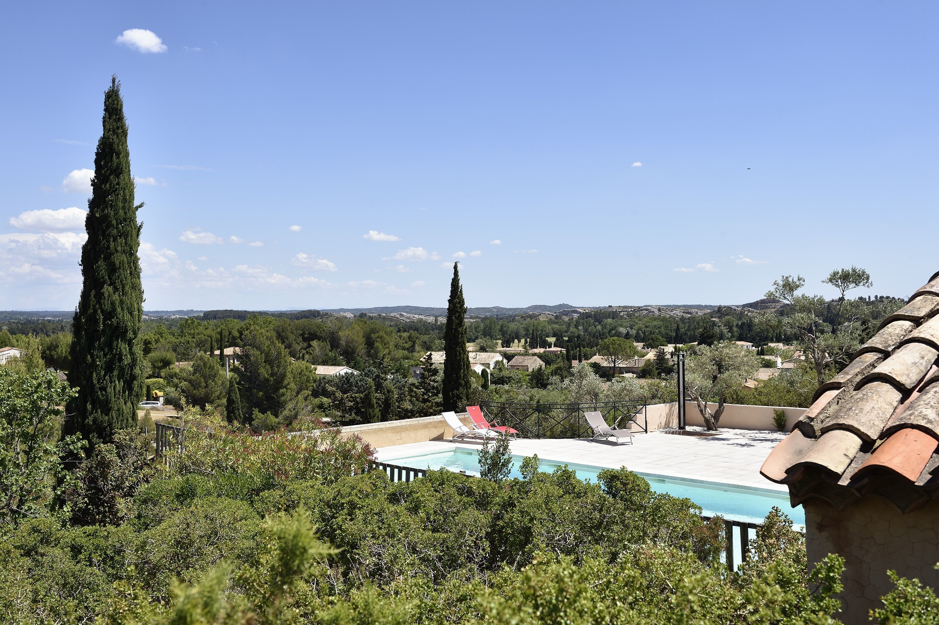A pool with a clear view of the surrounding landscape, including trees and distant hills.