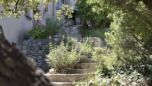 A stone staircase leading up to a building with a stone wall and a metal railing. - Mazet for 4 people. Les Garrigues Apt building of the valley of Baux Paradou (Paradou)