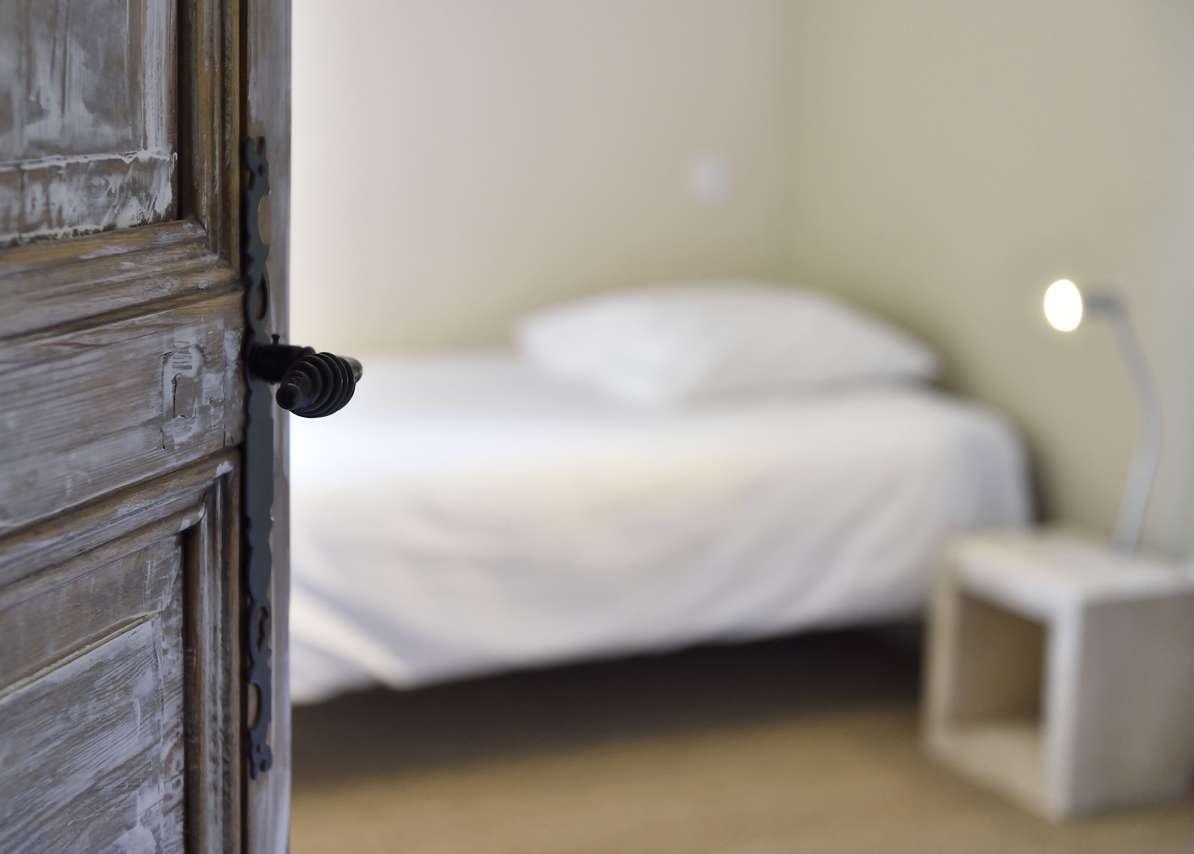 A bedroom with a bed, a bedside table, and a nightstand.