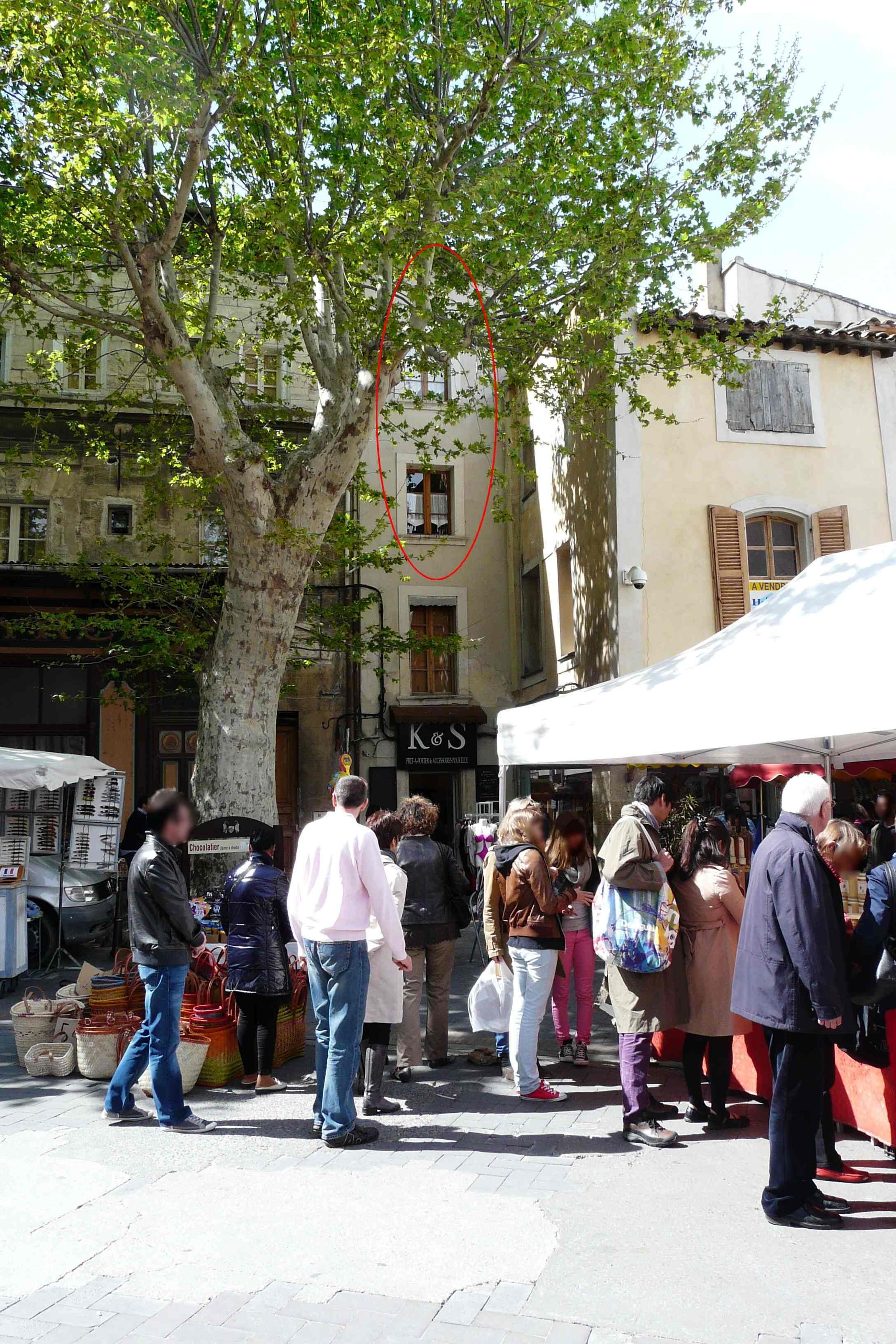 Un marché animé en plein air, où les gens font leurs emplettes et les vendeurs proposent leurs produits.
