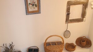 A staircase with a handrail, a wall-mounted picture frame, and several wicker baskets.