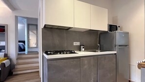 Une cuisine moderne équipée d’une cuisinière intégrée, d’un réfrigérateur et d’un four à micro-ondes.