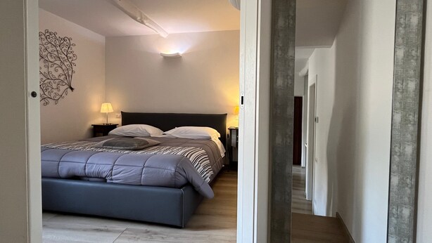 Une chambre moderne avec un grand lit, des lampes de chevet et un élément décoratif mural.