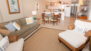 A living room with a sofa, armchair, and dining table. - GRAND POINTE 211....LOVELY CONDO, BEST VIEW, CLOSE TO AMENITIES  (Orange Beach)