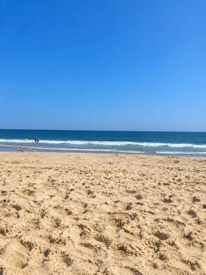 A beach with sand and waves.