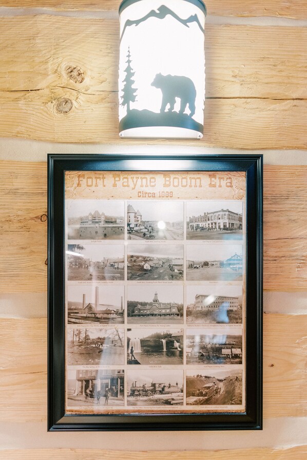 Un collage de photos historiques encadré, intitulé « L’âge d’or de Fort Payne, vers 1889 », avec une lampe en forme de silhouette d’ours placée au-dessus.
