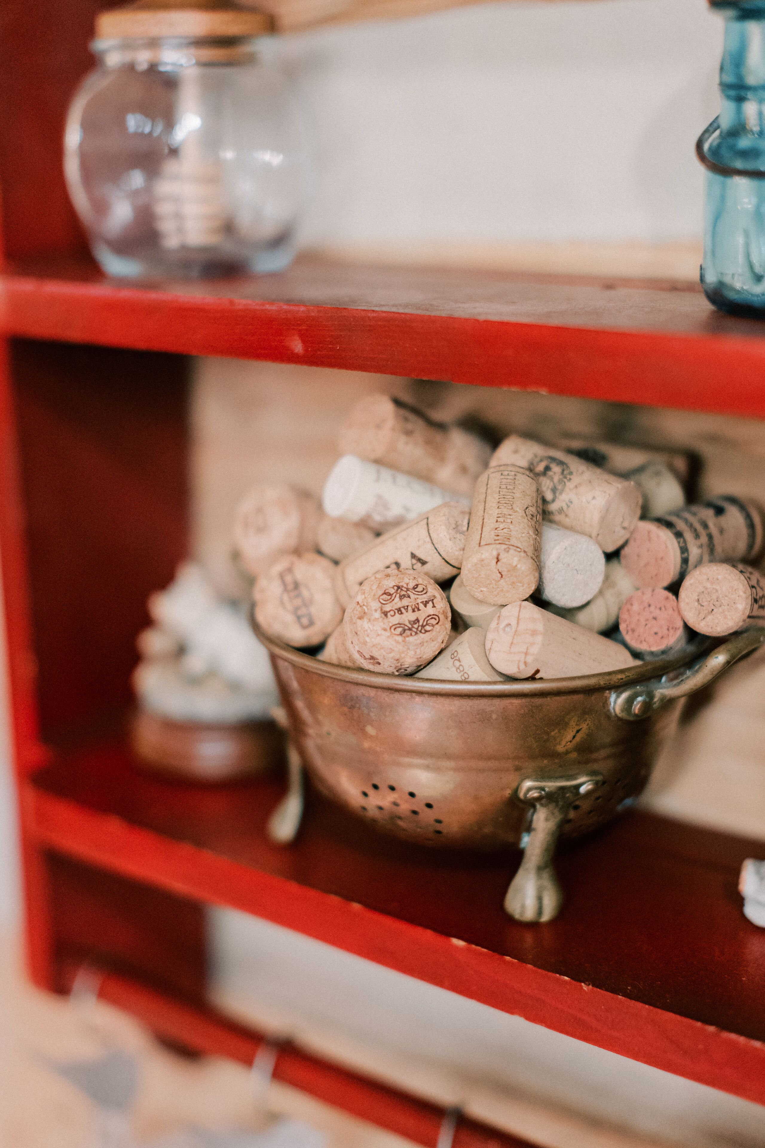 A metal bucket filled with wine corks on a shelf.