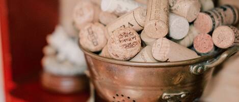A metal bucket filled with wine corks on a shelf.