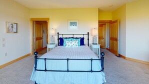 A bedroom with a bed, two nightstands, a lamp, and a framed picture on the wall.