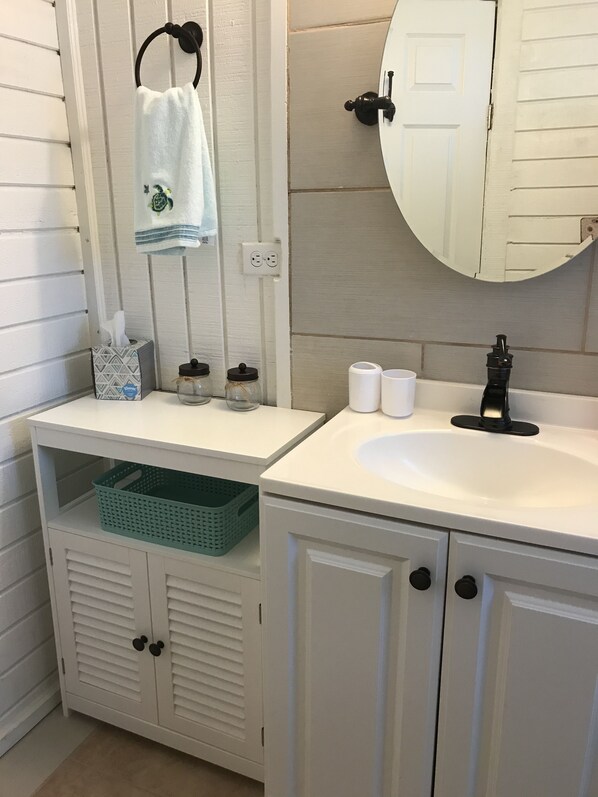 A bathroom with white cabinetry, a sink, a mirror, and a towel rack. - Entire 4 bedroom Loft, Best Value ~ 5 beds, 3 bathroom! Explore Long Island, BS (Long Island)