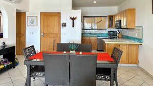A compact kitchen with wooden cabinets, a built-in microwave, and a tiled backsplash.