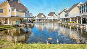 A waterfront property with a pond, houses, and a clear sky. - Sandpiper Cove 1090 2bed 2bath Beach Service new FALL DATES available! (Destin)