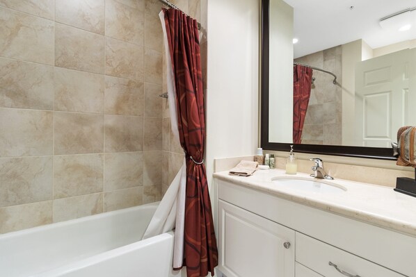 A bathroom with a bathtub, a sink, and a mirror. - Ave Maria Condo - Walking Distance from Ave Maria University and Church! (ave maria)