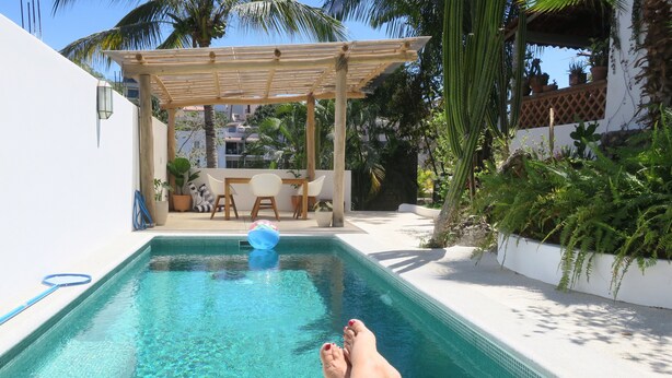 A pool with clear water, surrounded by a white wall and a wooden pergola. - Casa Solana, Wonderful Large Outdoor Porch and many French Doors plus Pool (Sayulita)