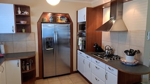Kitchen features a gas stove, refrigerator, and wooden cabinets.