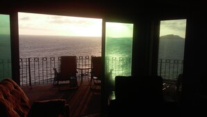 A room with a view of the sea, featuring a balcony with chairs and a table. -  Stunning ocean and one of Mazatlans top tourist attractions cliff divers view. (Mazatlán)