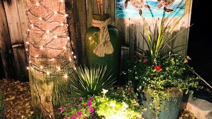 A garden with potted plants, a wooden sign with the number 1125, and string lights. - #404- 2 bed-1 bath sleeps 6- Fall beach getaway…& Winter Snowbirds! Book now! (Gulf Shores)