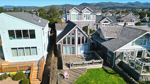 Un quartier résidentiel composé de plusieurs maisons dotées de grandes fenêtres et d’une terrasse en bois.