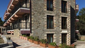 Un edificio de varios pisos con fachada de piedra, balcones y una escalera de piedra que conduce a la entrada.