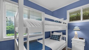 A bunk bed room with a window, a nightstand, and a lamp. - OCEAN FRONT: SEAS THE DAY:  Seaside Vacation Homes, Inc Managed  (Seaside)