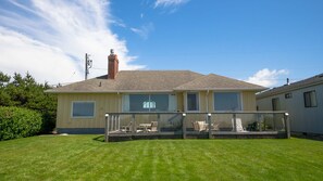 A single-story house with a covered patio area, large windows, and a chimney.
