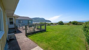 A house with a patio area featuring outdoor furniture and a view of the ocean.