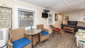 Un salon confortable avec des meubles en osier, un téléviseur à écran plat et un canapé.