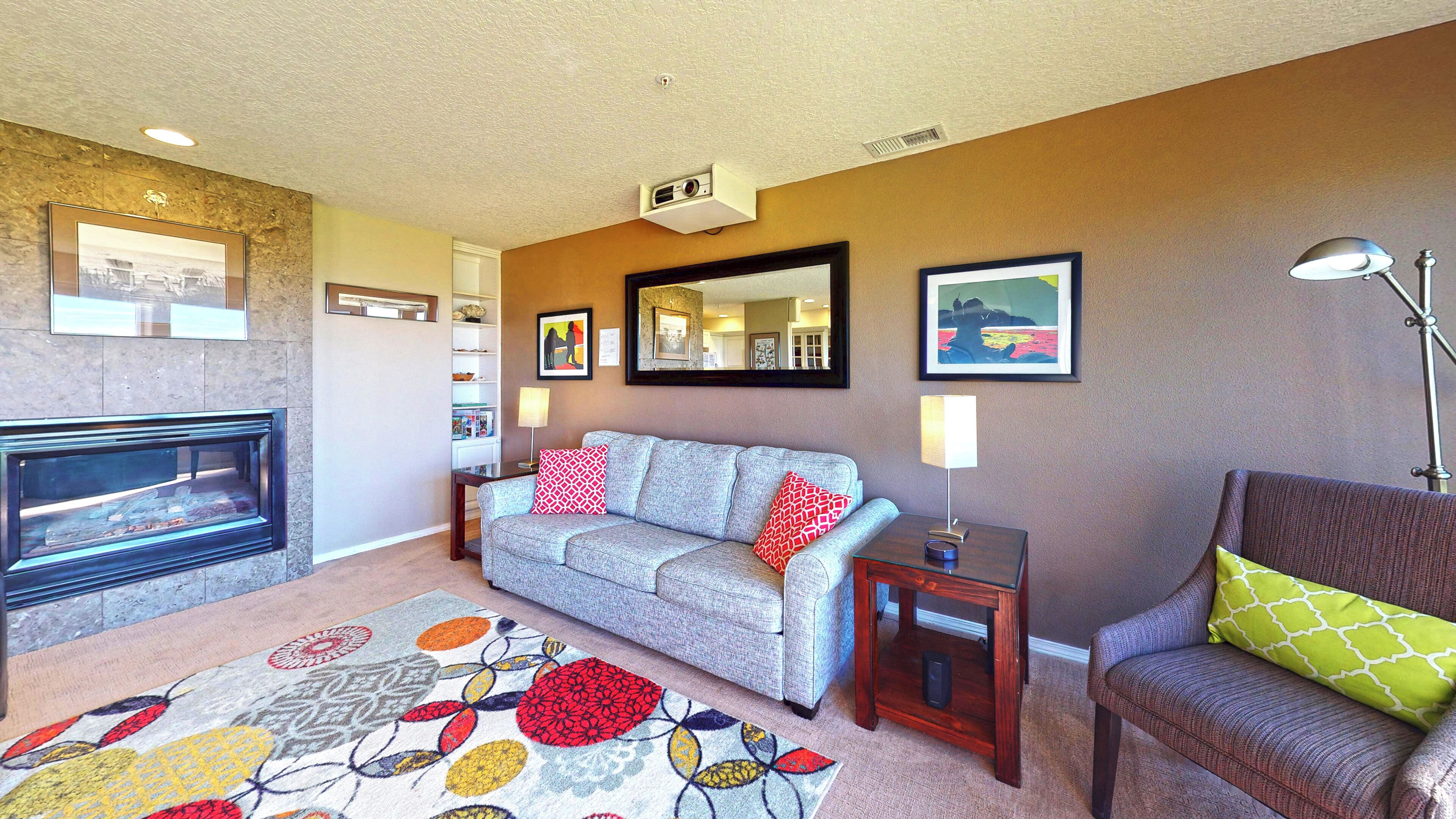 A living room with a fireplace, a sofa, a side table, and a lamp.