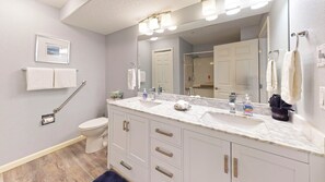A bathroom with a white toilet, a sink with a mirror above it, and a towel rack.