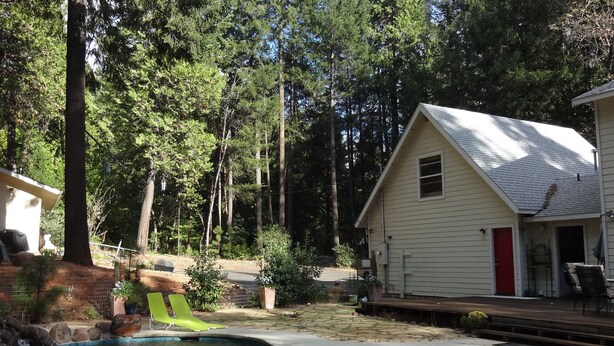 A residential area with a swimming pool, a house with a red door, and a wooden deck. - A Foresthill Retreat (Foresthill)