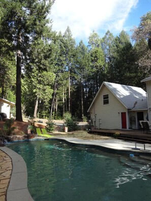 A residential area with a swimming pool, a house with a red door, and a wooden deck. - A Foresthill Retreat (Foresthill)