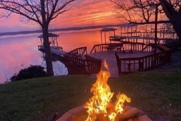 Outdoor fire pit as the sun sets over the lake