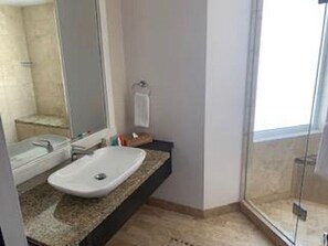 Features a spacious bathroom with a granite countertop, white sink, and large mirror.
