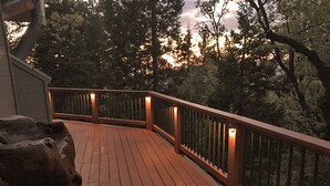 A wooden deck with railings and lights, surrounded by trees. - Inside Yosemite N.P. Gates, our luxury home is minutes from valley attractions. (Yosemite National Park)