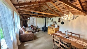 A rustic interior with a wooden dining table, a sofa, and a kitchen area. - Very rustic 1900's cabin. Unique 2 room 2 queen + shack @LittleTrailCreekCabins (Gardiner)
