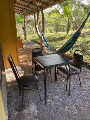 Relax in a shaded retreat surrounded by a pergola and trees, with a hammock and seating area.