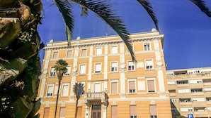 A building with a classical architectural style, featuring a symmetrical facade with evenly spaced windows and decorative elements around the windows and roofline. - Magic View Apartments (Zadar)