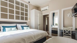 A bedroom with a large bed, a white bathtub, and a walk-in closet. - Magic View Apartments (Zadar)